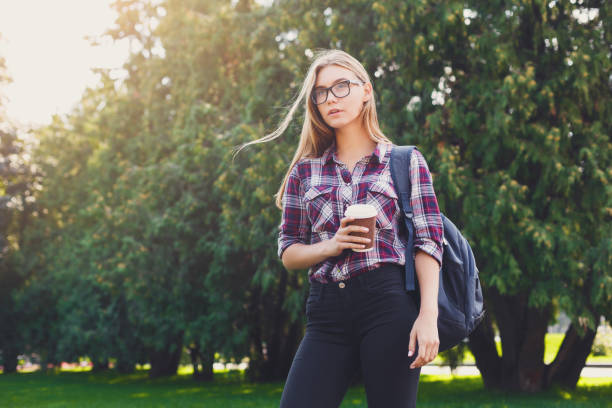 istock Student girl standing with coffee cup outdoors 985025022