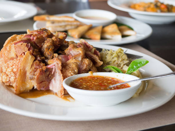 istock Crispy fried pork leg placed on a plate with vegetables and seasoning sauce 985025410