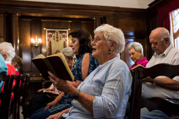 vue latérale d’une femmes âgées chantant à l’église - anglican photos et images de collection