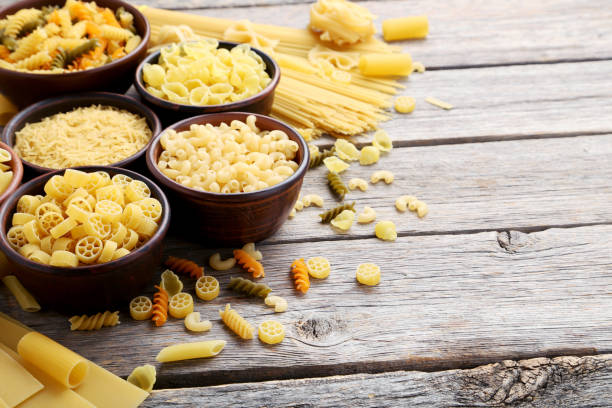istock Different kinds of pasta in bowls on grey table 985028180