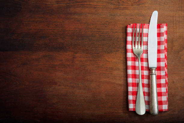 istock Table setting with fork knife and linen on wooden background 985029664