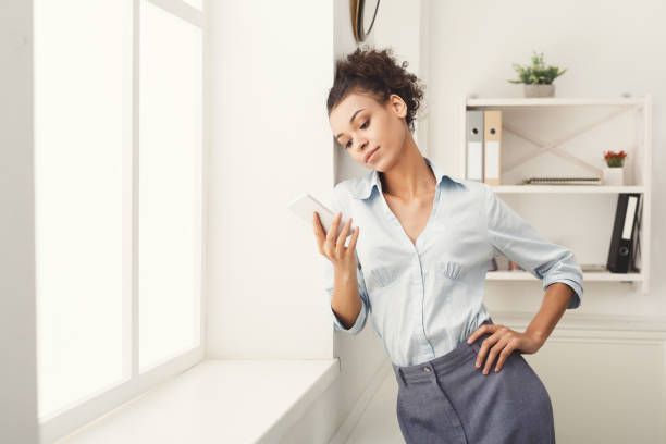 istock Business woman with mobile phone at office 985029666