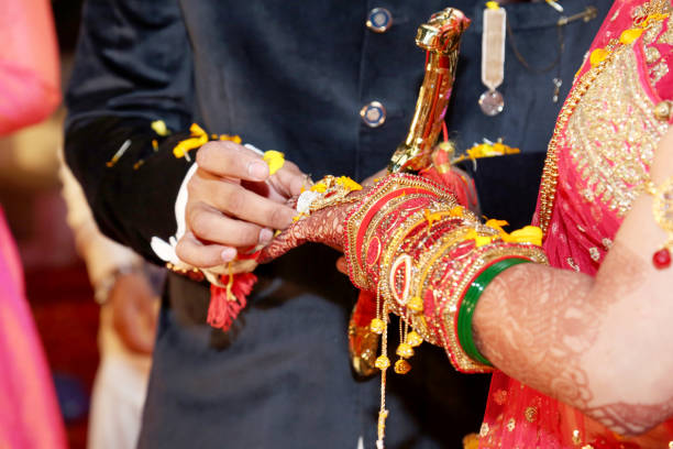 istock Indian groom putting ring on indian bride 985033016