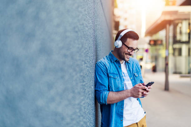 profitant de la musique - headphones relaxation outdoors caucasian photos et images de collection