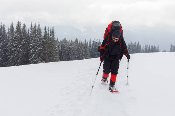 istock A hiker is climbing on the snow-capped hill 985038456