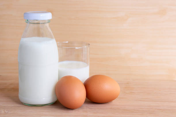 istock Bottle of milk and eggs on the wooden table. with copy space for text. 985042380