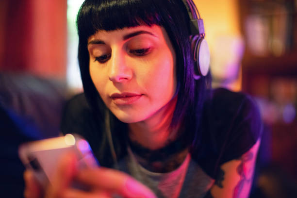 istock Young woman relaxing with smartphone on sofa 985046564