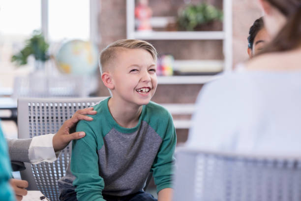 istock Elementary age schoolboy talks with group of kids 985047778