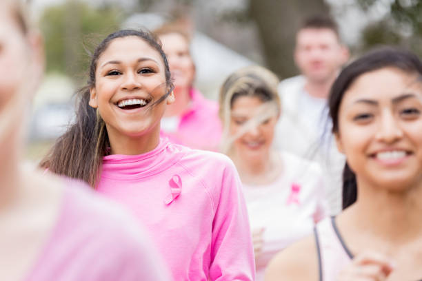 schöne junge frauen laufen in charity-rennen - laufveranstaltungen stock-fotos und bilder