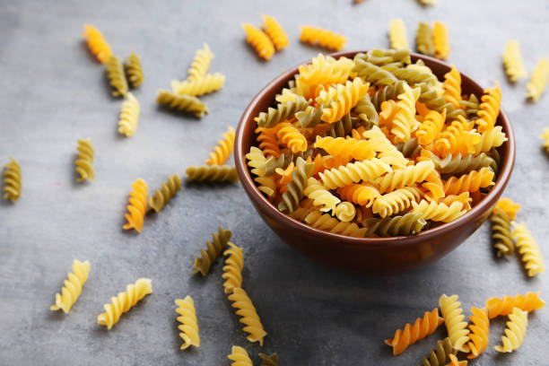 istock Spiral pasta on the grey wooden table 985048368