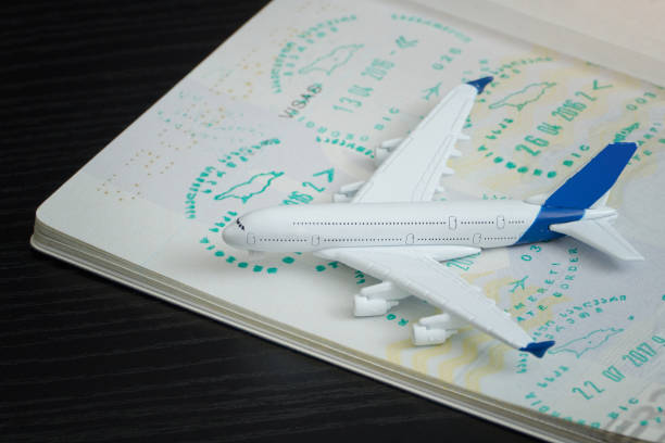 istock Airplane and open passport with a visa. Close up 985051176