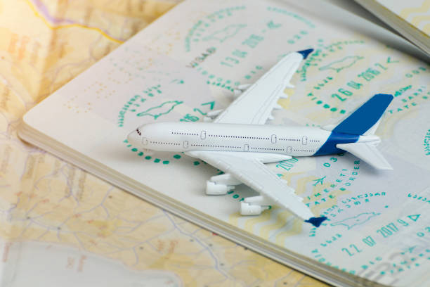 istock Airplane on passport pages with a visa. Close up 985051178