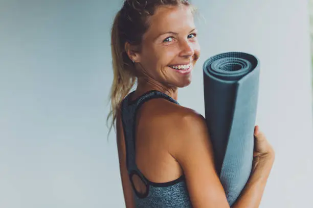 Healthy living- young woman with yoga mat