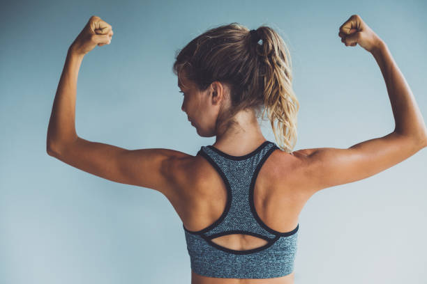 istock Fitness woman flexing muscles 985053378