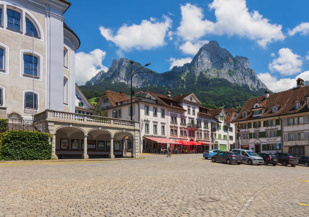 Hauptplatz square in the town of Schwyz, Switzerland Schwyz, Switzerland - June 23, 2018: buildings and people on Hauptplatz square the historical part of the town of Schwyz, the Kleiner Mythen and Grosser Mythen summits in the background. The town of Schwyz is the capital of the Swiss canton of Schwyz. schwyz stock pictures, royalty-free photos & images