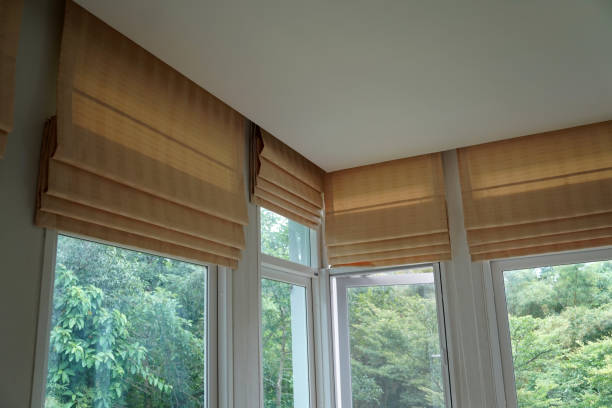 istock brown roman blind shade curtain and shadow tree forest mountain background 985057498