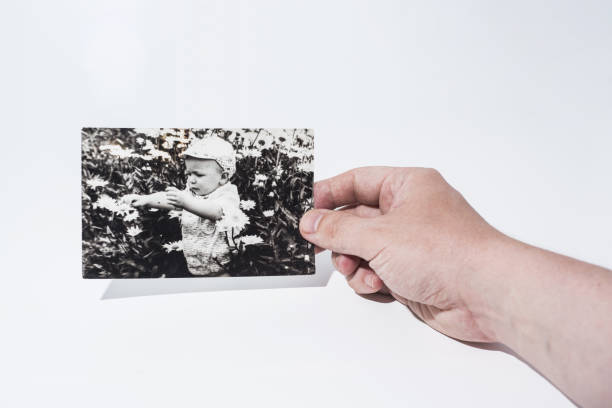 istock Old paper photo in mans hands. 985058464