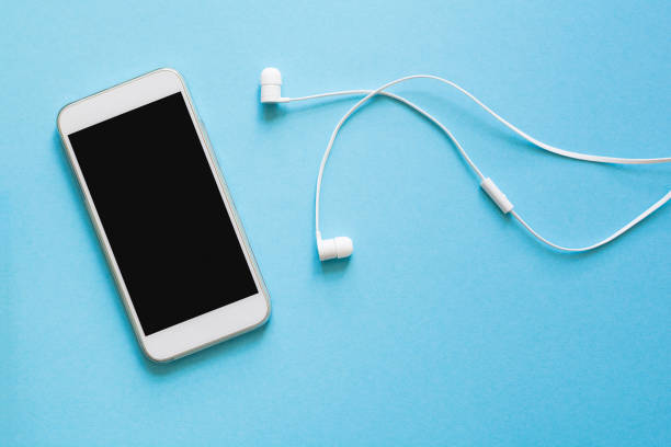 istock Top view mock-up smartphone and earphones on blue background. Flat lay. Space for copy 985059084
