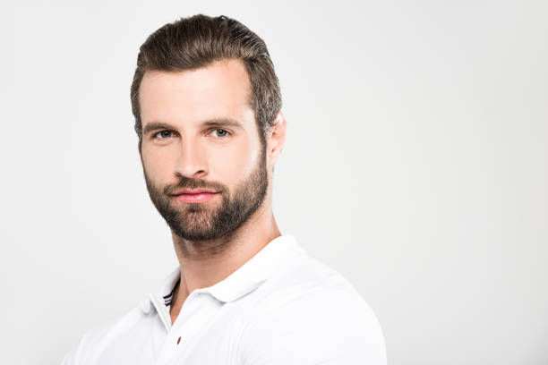 istock portrait of handsome bearded man looking at camera, isolated on grey 985063610