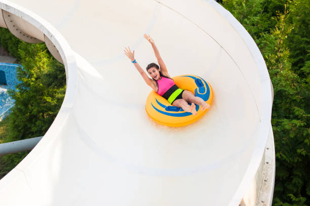 istock Girl on a rubber inflatable float on a water slide 985063616