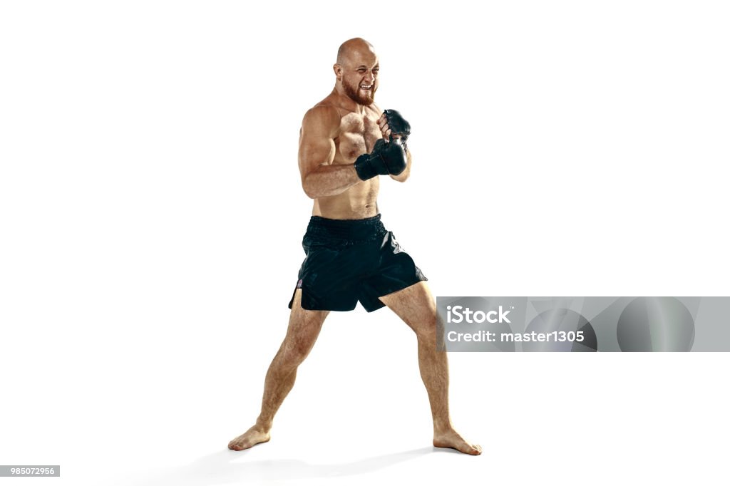 professional boxer boxing isolated on white studio background MMA. The professional boxer boxing isolated on white studio background. Fit muscular caucasian athlete fighting. Sport, competition, excitement and human emotions concept Mixed Martial Arts Stock Photo