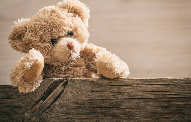 istock Teddy bear on wooden background 985074020