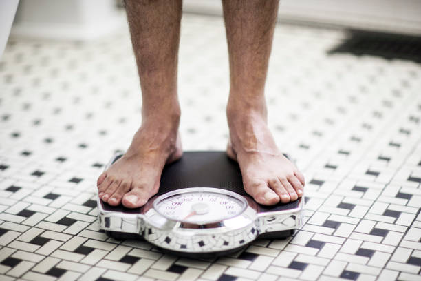 istock Adult man on bathroom scales. 985082410