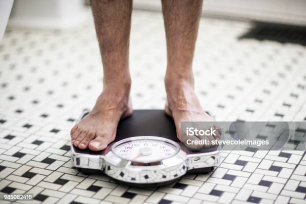 Adult Man On Bathroom Scales Stock Photo - Download Image Now - Weight Scale, Men, Scale