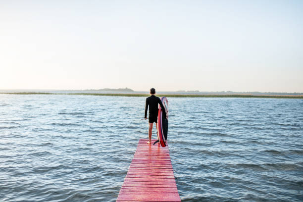 istock Man with paddleboard near the lake 985082630