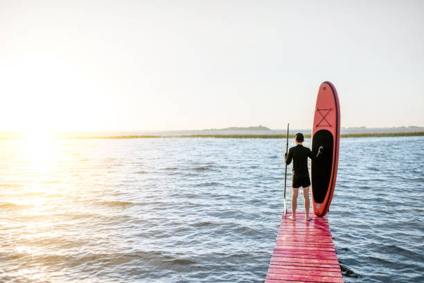 A man on a sup swims at the Rummu quarry, photo view from a drone.