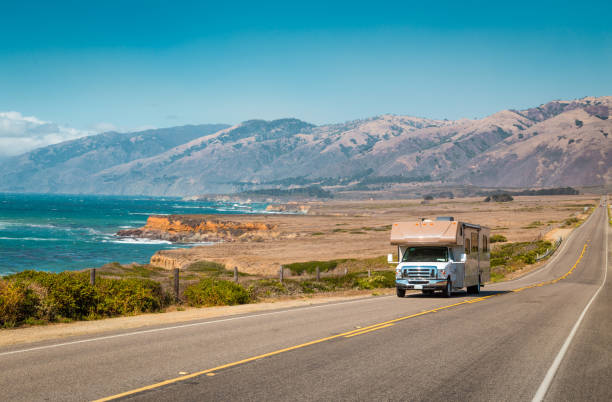 a white motorhome drives along in a deserted road