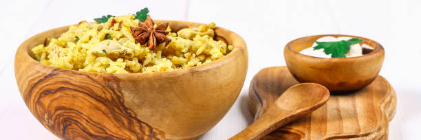 indische biryani mit huhn, joghurt und gewürzen in einer platte auf einem holztisch. silvester, weihnachten gericht. - nonvegetarian stock-fotos und bilder