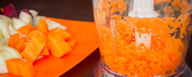 istock Carrots for borsch in an electric chopper. Soup cooking. 985085988