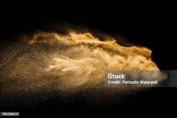 Golden Colored Sand Splash Against Dark Background Yellow Sand Fly Wave In The Air Stock Photo - Download Image Now