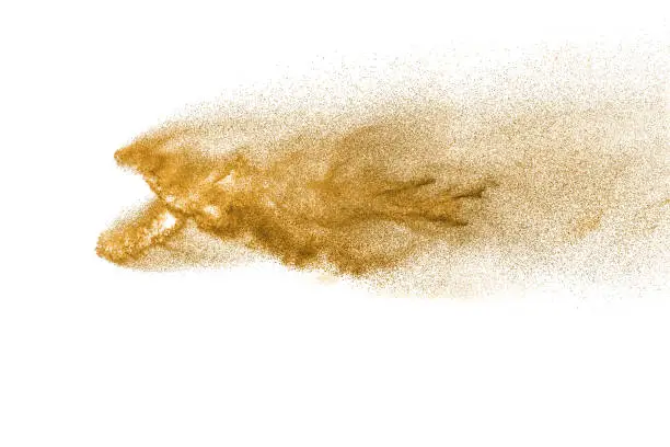 Golden sand explosion isolated on white background. Abstract sand cloud.