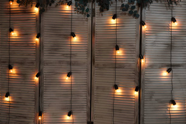 istock Glowing light bulbs hang on wires in a garland 985090948