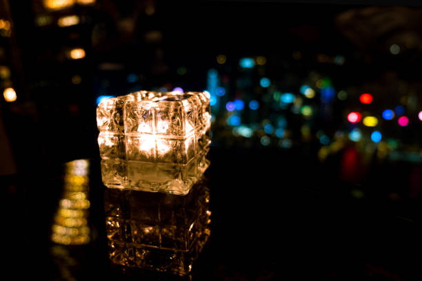 istock Burning candle in glass cup with abstract background 985092094