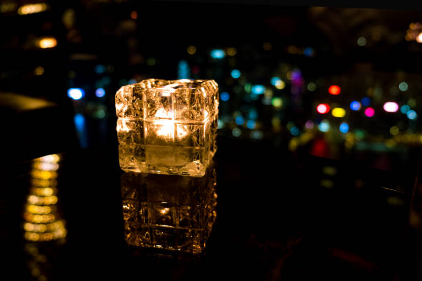 istock Burning candle in glass cup with abstract background 985092140