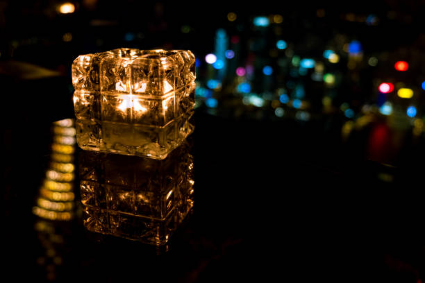 istock Burning candle in glass cup with abstract background 985092260