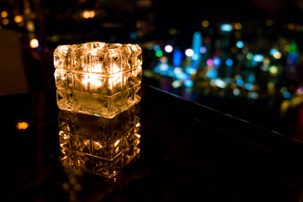 istock Burning candle in glass cup with abstract background 985092302