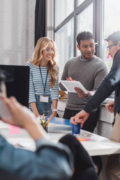istock cropped image of people using tablet behind woman speaking on smatrphone at office 985100450