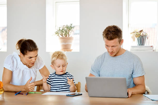 istock Mother assisting son in maths by father at table 985108216