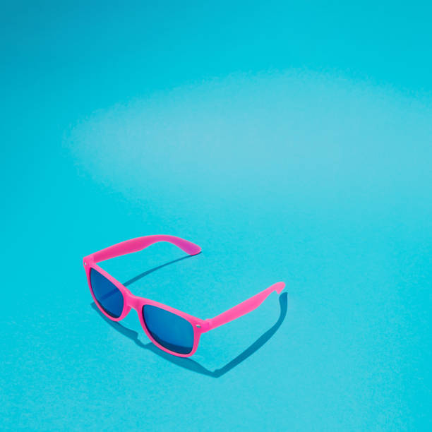 istock Pink sunglasses on pastel blue background. Minimal summer concept. 985109602