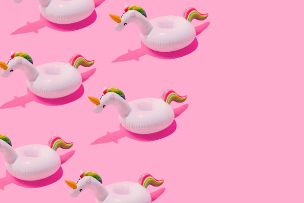 istock Inflatable unicorn pool toy pattern on pastel pink background with copy space. Minimal summer concept. 985110498