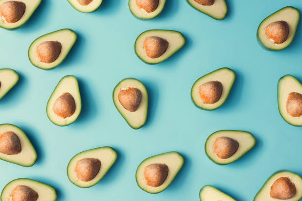 istock Avocado colorful pattern on a pastel blue background. Summer concept. Flat lay. 985110952