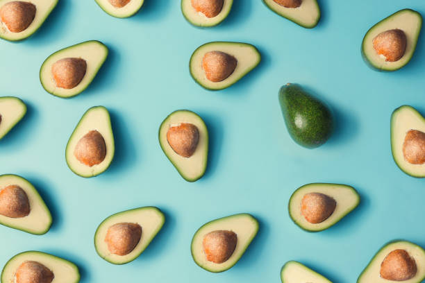 istock Avocado colorful pattern on a pastel blue background. Summer concept. Flat lay. 985114922