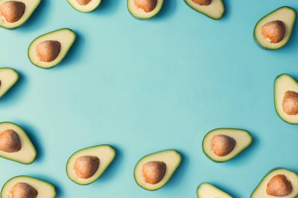 istock Avocado colorful pattern on a pastel blue background. Summer concept. Flat lay. 985114974