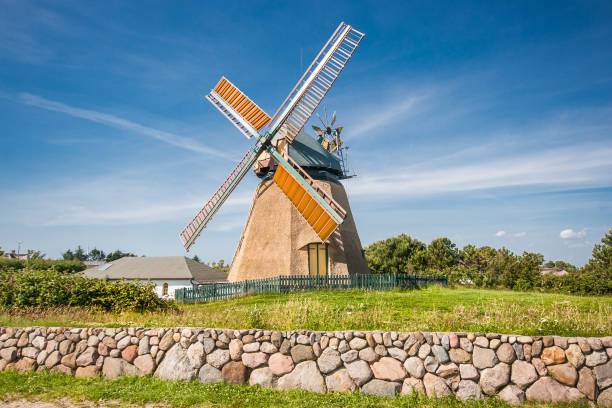 Beautiful dune landscape with traditional lighthouse at North Sea Traditional windmill in beautiful scenery with blue sky and clouds on a sunny day in summer danish culture photos stock pictures, royalty-free photos & images