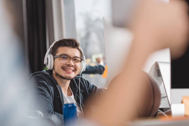 istock young man in headphones at modern office 985118008