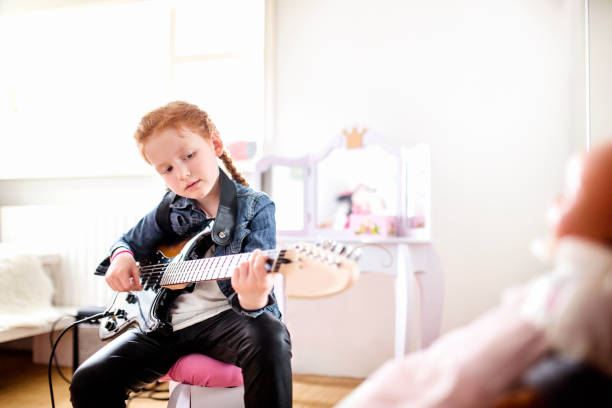 istock Reverse role. GIRL playing guitar 985118114